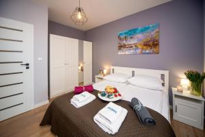 a bedroom with a bed with a plate of food on it at Maya's Flats & Resorts 62 - 3 rooms apartment BASTION WALOWA Gdańsk in Gdańsk
