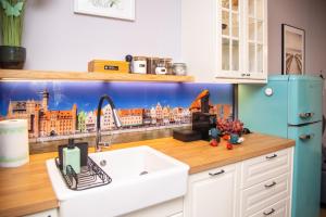 a kitchen with a sink and a city mural on the wall at Maya's Flats & Resorts 62 - 3 rooms apartment BASTION WALOWA Gdańsk in Gdańsk