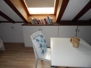 a white chair with a white table and a window at Casa Libra in Düsseldorf