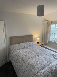 a bedroom with a bed and a window with a candle at Myrtle Cottage Boscastle in Boscastle