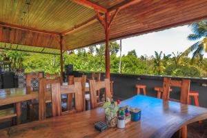 a dining area with a wooden table and chairs at THE DARA HILL in Nusa Penida