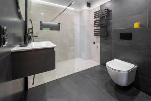 a bathroom with a white toilet and a sink at Rezydencja Strążyska in Zakopane