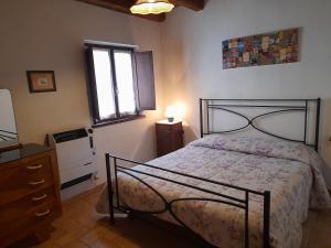 1 dormitorio con 1 cama, vestidor y ventana en Agriturismo Casale Sant'Antonio, en Cascia