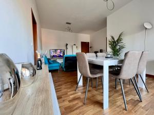comedor y sala de estar con mesa blanca y sillas en APPARTAMENTO DE LUXE GIADA, en Bolonia