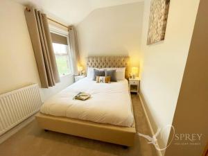 a bedroom with a large white bed with a window at Sunnybank - Traditional 3 bedroom cottage in Lincolnshire