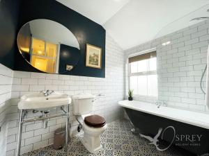 y baño con bañera, aseo y lavamanos. en Sunnybank - Traditional 3 bedroom cottage en Lincolnshire