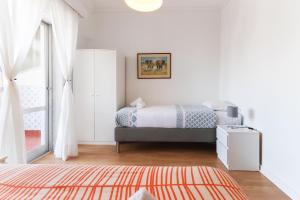- une chambre blanche avec un lit et une fenêtre dans l'établissement Oeiras Balcony by Homing, à Oeiras