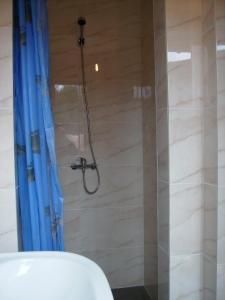 a bathroom with a shower with a blue shower curtain at Camping domki letniskowe in Warsaw