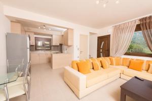 a living room with a couch and a kitchen at Vila Mond Sea View Apartments in Kinira