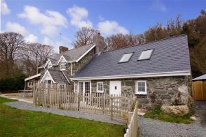 a house with a wooden fence in front of it at The Barn in Bala