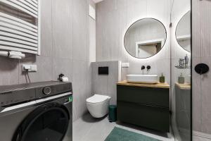 a bathroom with a washing machine and a sink at Uroczy ,,Bursztynowy ,, apartament blisko plaży , parking w cenie in Gdańsk