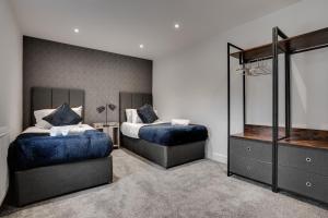 a bedroom with two beds and a mirror at Victoria Home - 2 Bedroom Wi-Fi Parking Workers in Hyde