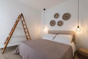 een kamer met een bed met een ladder en klokken aan de muur bij LIBERTY in Torre San Giovanni Ugento