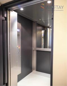 an elevator with a glass door in a building at Thresh Apartments Airport by Airstay in Spáta