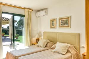 a bedroom with two beds and a balcony at Luxury Golf Villa Torremirona in Navata +34 photos