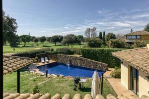 una piscina en un patio con una casa en Luxury Golf Villa Torremirona, en Navata