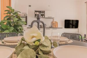 a dining room table with a white flower on it at Varenna Wanderlust in Perledo