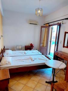 a bedroom with a large bed and a table at Stella Apartments in Marathokampos