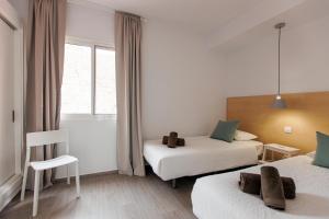 a hotel room with two beds and a window at Chalet adosado en Pasito PTOM23 in Pasito Blanco