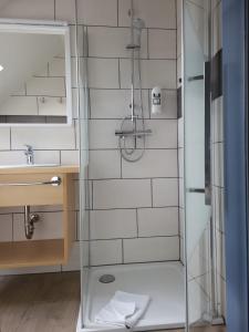 eine Dusche mit Glastür im Bad in der Unterkunft Hotel Am Deich in Norddeich