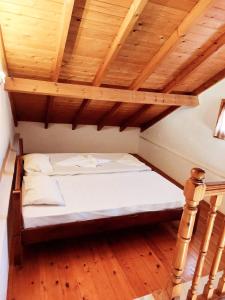 Cama en habitación con techo de madera en Stella Apartments, en Marathokampos