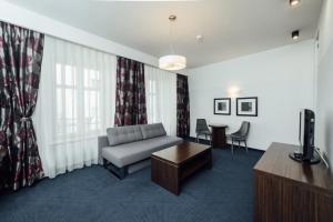 uma sala de estar com um sofá e uma mesa em Hotel Rezydent em Cracóvia