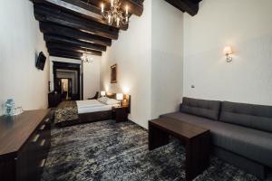 a living room with a couch and a bed at Hotel Rezydent in Kraków