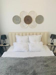 sypialnia z łóżkiem z 3 płytami na ścianie w obiekcie - Enjoy Cozy Apartment, Close To City Center - w Taszkiencie