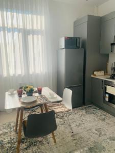kuchnia ze stołem, krzesłami i lodówką w obiekcie - Enjoy Cozy Apartment, Close To City Center - w Taszkiencie