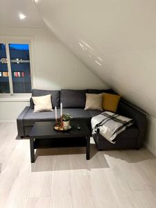 a living room with a couch and a table at Ny og moderne 2-roms leilighet in Bodø