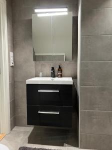 a bathroom with a sink and a mirror at Ny og moderne 2-roms leilighet in Bodø