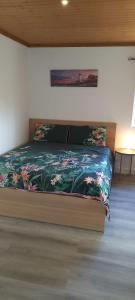 a bedroom with a bed with a floral bedspread at 2 bedroom Sintra Zen in Sintra