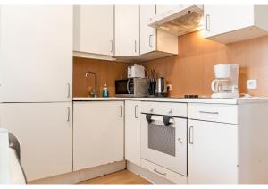 a kitchen with white cabinets and a white refrigerator at Viennese 3BR shared Apt. Near Wiener Stadthalle & Central in Vienna