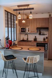 a kitchen with two bar stools and a counter top at Martine & Thomas Santa Lucia in Saint-Raphaël