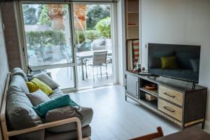 a living room with a couch and a flat screen tv at Martine & Thomas Santa Lucia in Saint-Raphaël