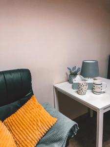 un escritorio con una silla y una mesa con tazas. en Hostel Przed Świtem, en Gorzów Wielkopolski