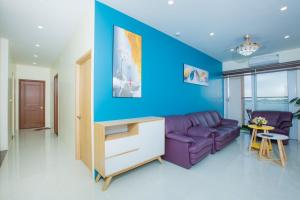 a living room with a purple couch and a blue wall at Penhouse 4 ngủ View biển rộng 160m2 in Ha Long