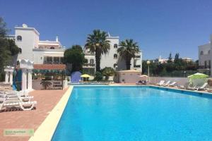a large swimming pool in front of a building at Green Apartment in Tavira Garden in Tavira