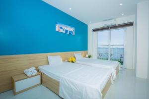 2 camas en una habitación con una pared azul en Penhouse 4 ngủ View biển rộng 160m2 en Ha Long