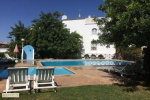 a pair of chairs sitting next to a swimming pool at Green Apartment in Tavira Garden in Tavira