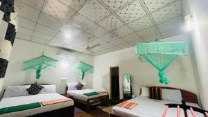 um quarto com duas camas com guarda-sóis no tecto em Lal Home Stay em Sigiriya