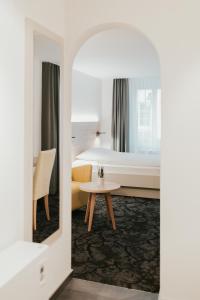 una camera d'albergo con letto e tavolo di Gartenhaus by Ochsen Lenzburg a Lenzburg