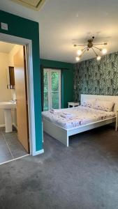 a bedroom with a bed and a green wall at Cheerful 4-bedroom house with multiple car parking in Manchester