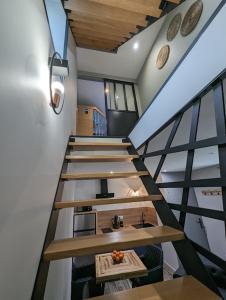 Un escalier dans une maison avec un tas de tables dans l'établissement Déliv'Love, à Douvres-la-Délivrande