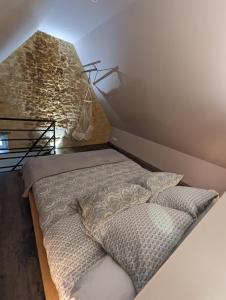 a bed in a room with a brick wall at Déliv'Love in Douvres-la-Délivrande