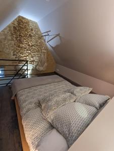 Ce lit se trouve dans une chambre dotée d'un mur en briques. dans l'établissement Déliv'Love, à Douvres-la-Délivrande
