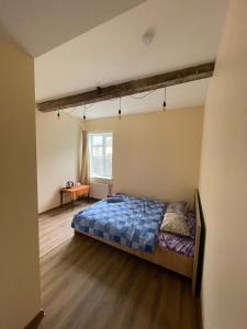 Un dormitorio con una cama y una mesa. en KurBrauksim Windau Rooms, en Ventspils