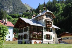 Una casa grande con una cruz encima. en Apartments Alpenrose, en Flirsch