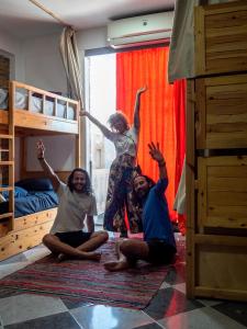 un grupo de tres personas sentadas en el suelo en un dormitorio en My Hostel in Dahab - Dive center, en Dahab
