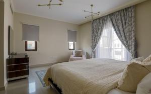 - une chambre avec un grand lit et une fenêtre dans l'établissement Spacious,amazing villa with a beautiful blooming garden!, à Dubaï
